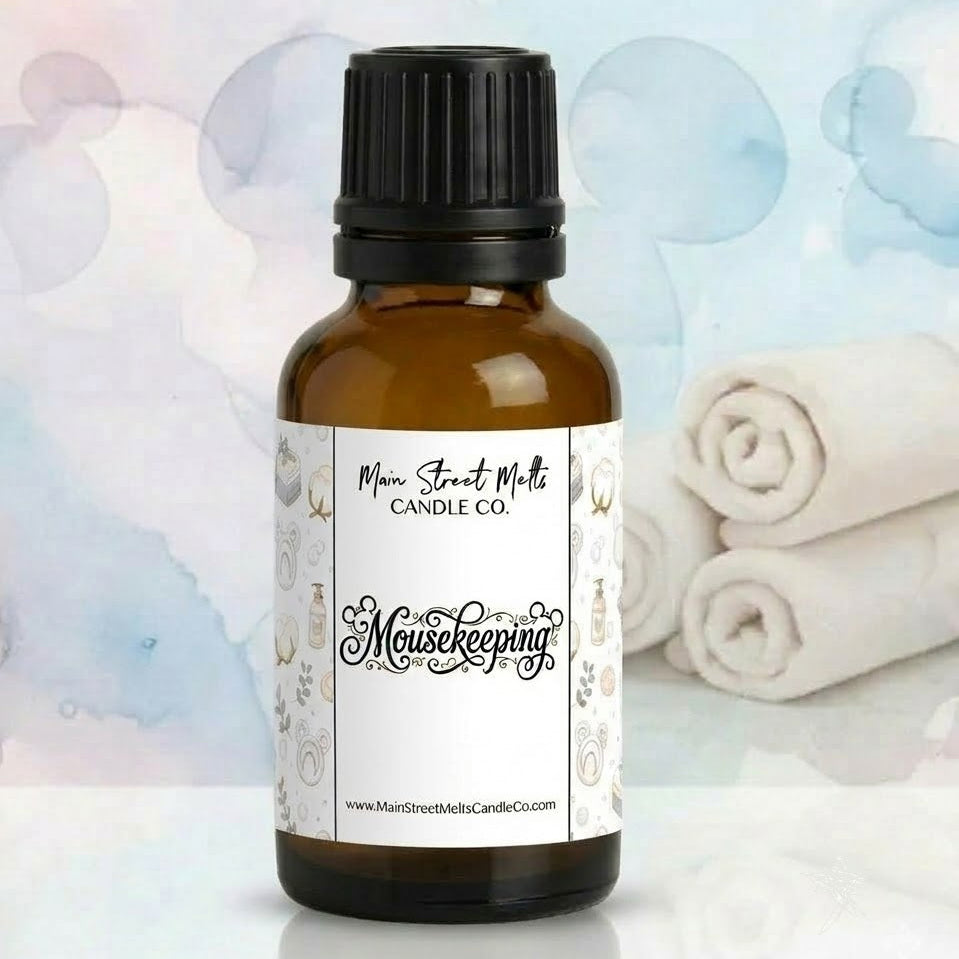 Bottle of Mousekeeping essential oil with a blurred background featuring towels and bath products.